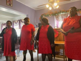 Four women in red singing during worship